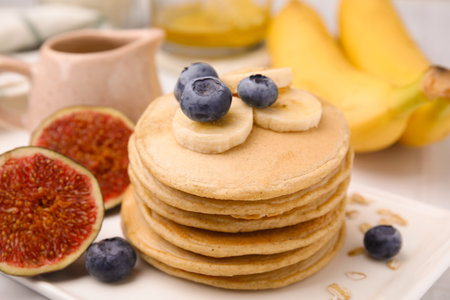 Tasty oatmeal pancakes with fruits on plate, closeupの写真素材