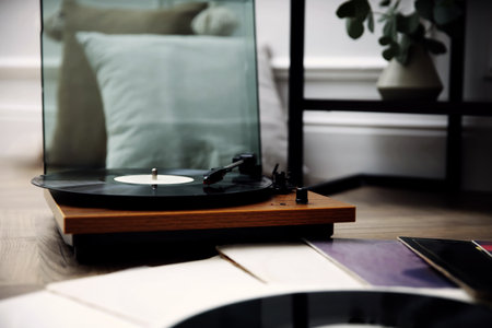 Stylish turntable with vinyl records on floor indoorsの写真素材