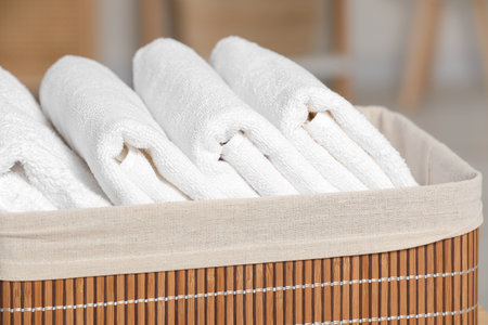 Wicker basket with folded soft terry towels indoors, closeupの写真素材