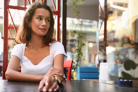 Portrait of a beautiful young woman in an outdoor cafe. Space for text