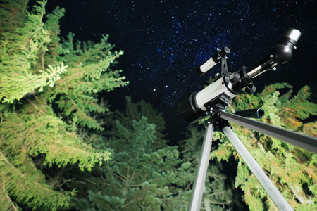 Modern telescope at night outdoors, low angle view. learning astronomy