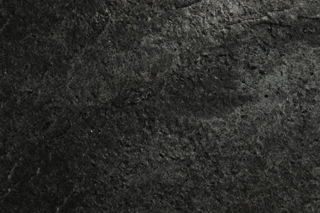 Texture of dark gray stone surface as background, closeup