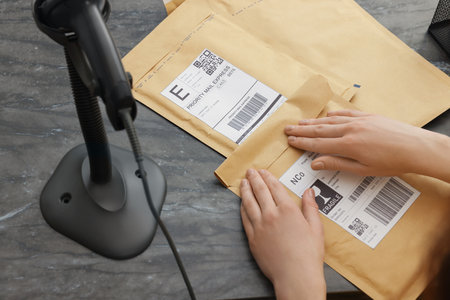 Post office worker with envelopes at table indoors, closeupの写真素材