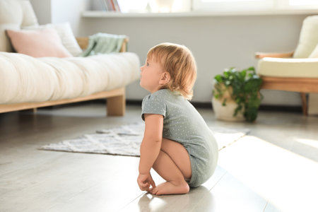 Cute baby learning to walk in living roomの写真素材