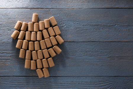 Grape made of wine bottle corks on gray wooden table, top view. Space for text