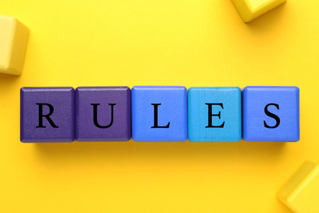 Word Rules made of colorful cubes with letters on yellow background, flat layの写真素材