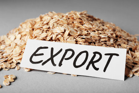 Pile of oatmeal and paper card with word Export on gray background, closeup