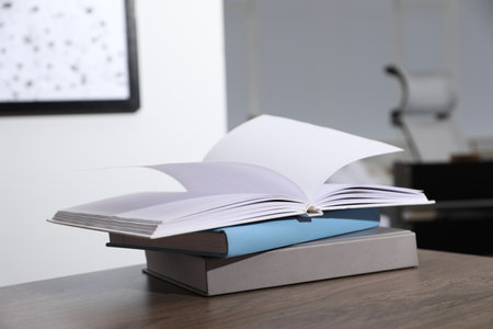 Stack of different hardcover books on wooden table indoorsの写真素材