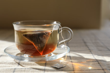 Tea bag in glass cup on table, closeup. Space for textの写真素材