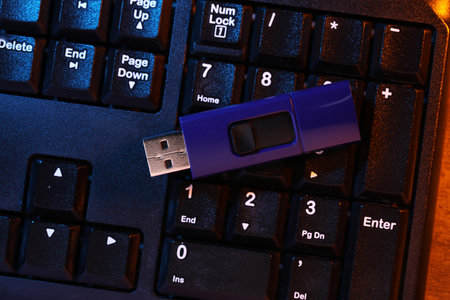Modern usb flash drive on computer keyboard, top viewの写真素材
