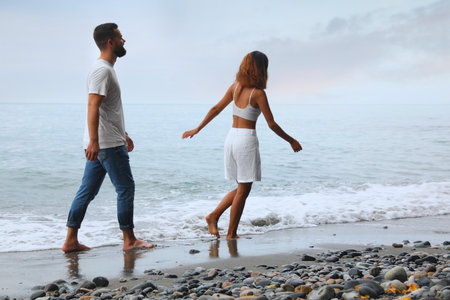 Happy young couple spending time together on beach near seaの写真素材