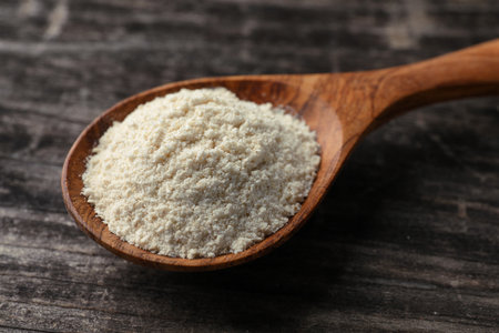 Spoon with quinoa flour on black wooden table, closeupの写真素材