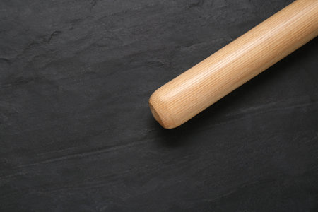 Baseball bat on black background, top view with space for text. sports equipment