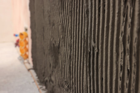 Adhesive mix for tile installation on wall indoors, closeup