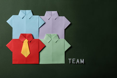 Many paper shirts and word Team on green background, flat lay with space for text. Recruiter searching employeeの写真素材