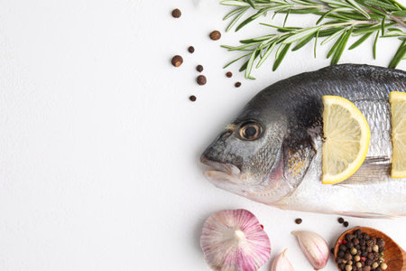 Flat lay composition with fresh raw dorado fish and ingredients on white table, space for textの写真素材