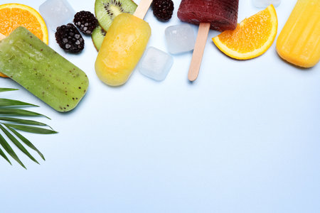 ice lolly, fresh fruits and ice cubes on light background, flat lay. Space for text
