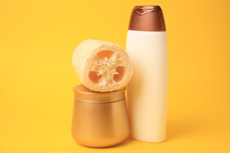 Natural loofah sponge and cosmetic products on yellow backgroundの写真素材