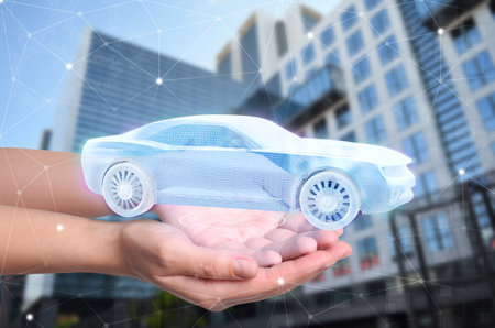 Woman holding digital image of modern car outdoors, closeup