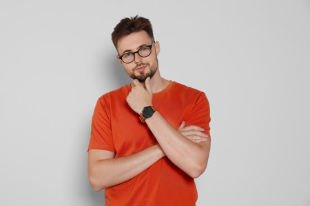 Handsome man in eyeglasses on light gray background