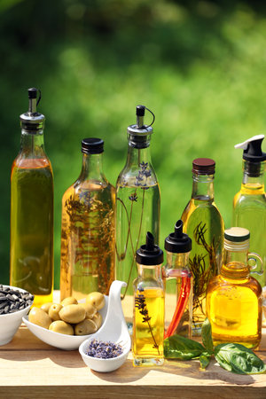 Different cooking oils and ingredients on wooden table against blurred green backgroundの写真素材