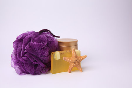 Purple shower puff, cosmetic products and starfish on white backgroundの写真素材