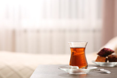 Glass with traditional Turkish tea and cookies on table indoors. Space for textの写真素材