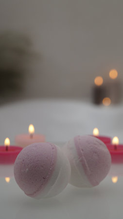 Bath bombs with burning candles on tub indoors. bokeh effectの写真素材