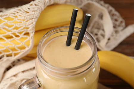 Mason jar with banana smoothie on wooden table, closeupの写真素材