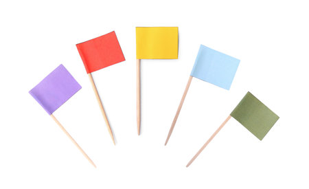 Set of toothpicks with small colorful paper flags on white background, top viewの写真素材