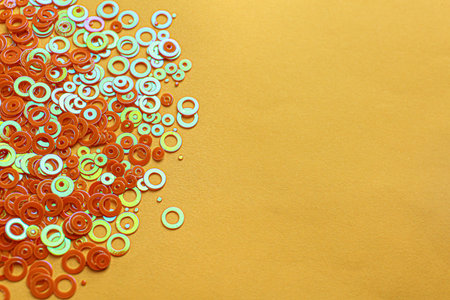 Shiny bright glitter on pale orange background. Space for text