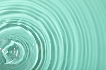 Close up view of water with rippled surface on light blue backgroundの写真素材