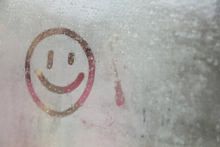 Happy face drawn on foggy window, space for text. rainy weatherの写真素材