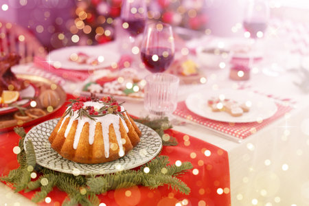 Festive dinner with delicious cake served on table indoors. Christmas eve celebrationの写真素材