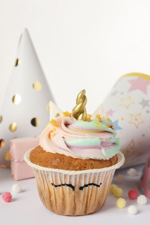Cute sweet unicorn cupcake and party hats on white background, closeupの写真素材