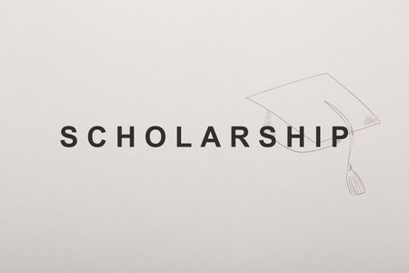 Word SCHOLARSHIP and academic cap on white paperの写真素材