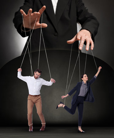 Human relationships demonstrated in puppet show. Workers manipulated by director or manager on dark...