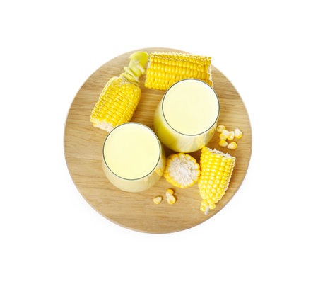 Tasty fresh corn milk in glasses and cobs on white background, top viewの写真素材
