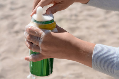Woman opening can with sparkling drink at beach, closeupの写真素材