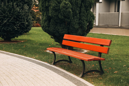 Beautiful bushes, pathway and bench in parkの写真素材
