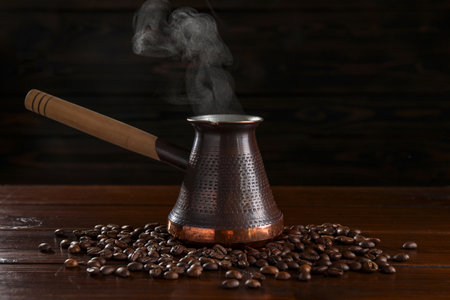 Turkish coffee in cezve and beans on wooden tableの写真素材