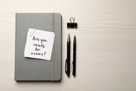Note with question Are You Ready For Exams? on white wooden table, flat lay. Space for textの写真素材