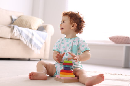 Cute little child playing with toy on floor at homeの写真素材