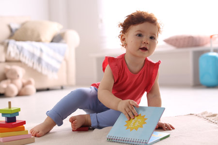 Cute little child playing with toys on floor at home