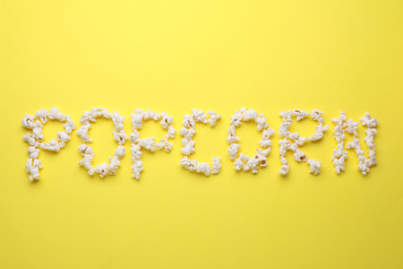 Word Popcorn made of tasty ingredients on yellow background, top viewの写真素材