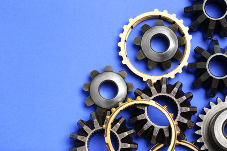 Different stainless steel gears on light blue background, flat lay. Space for textの写真素材