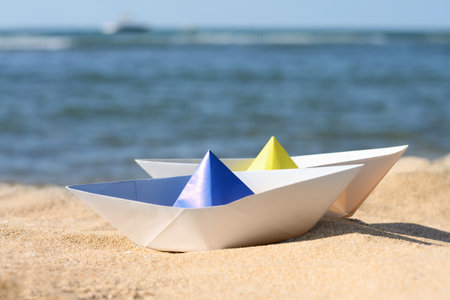 Two paper boats near the sea on sunny day, closeupの写真素材