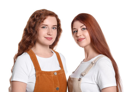 Portrait of beautiful young redhead sisters on white backgroundの写真素材