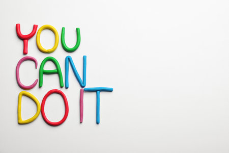 Motivational phrase You Can Do IT made of colorful plasticine on white background, flat lay. Space for textの写真素材