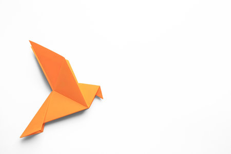 Beautiful orange origami bird on white background, top view. Space for textの写真素材